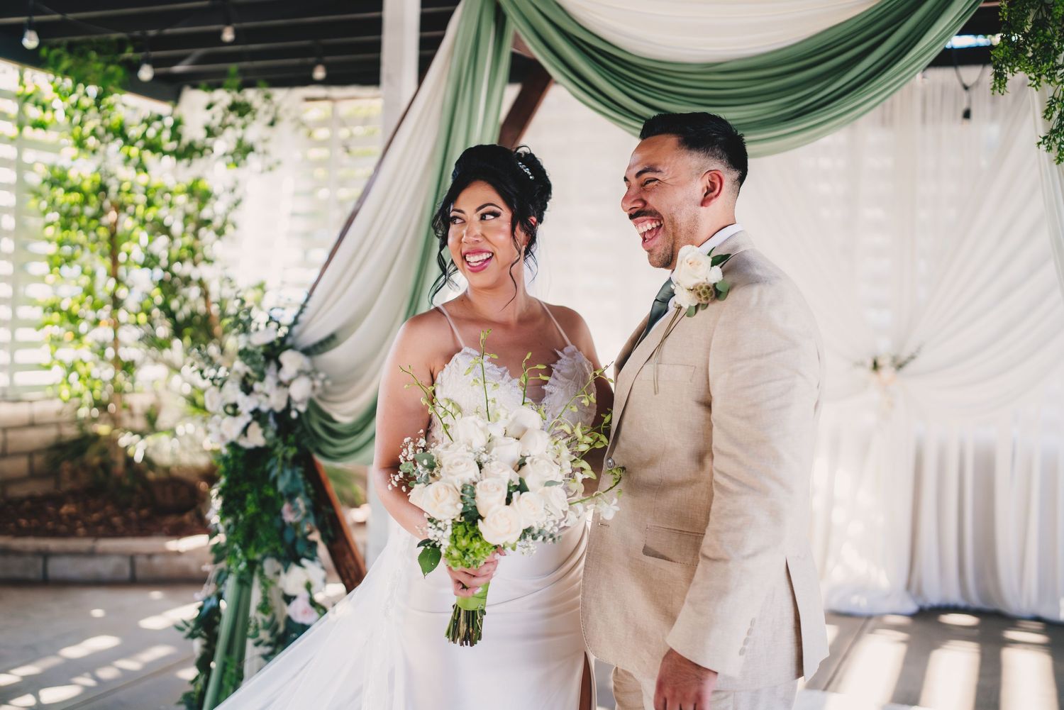 Newlyweds share joyful moments during their green and white themed wedding celebration.