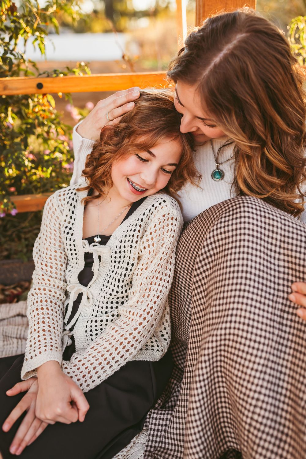 A candid moment captured between two people in checkered and crochet outfits during sunset at Blooming Ridge Ranch.