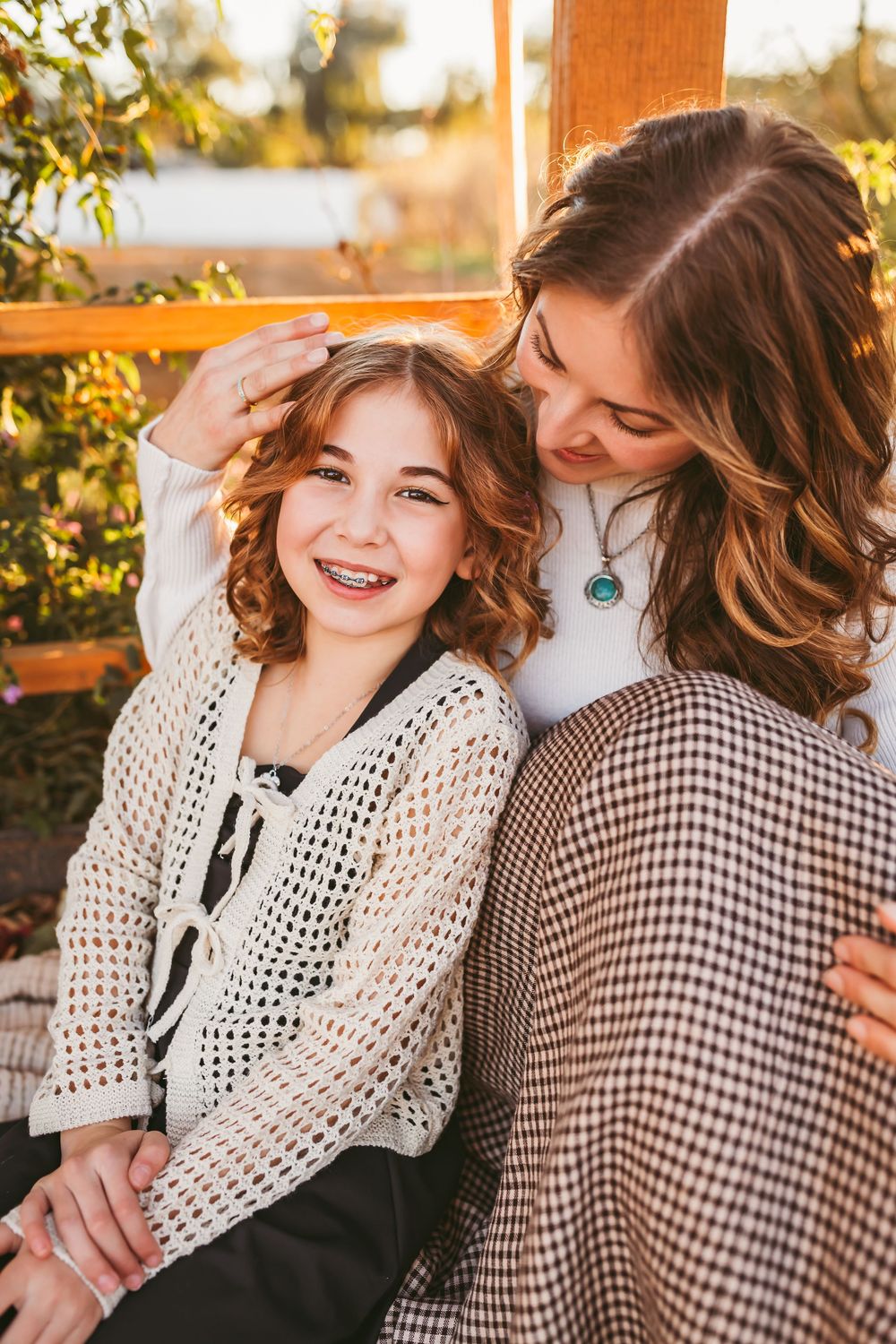 A sweet moment captured in warm sunlight showing a pair in a checkered shirt and white crochet sweater sharing laughter in Beaumont