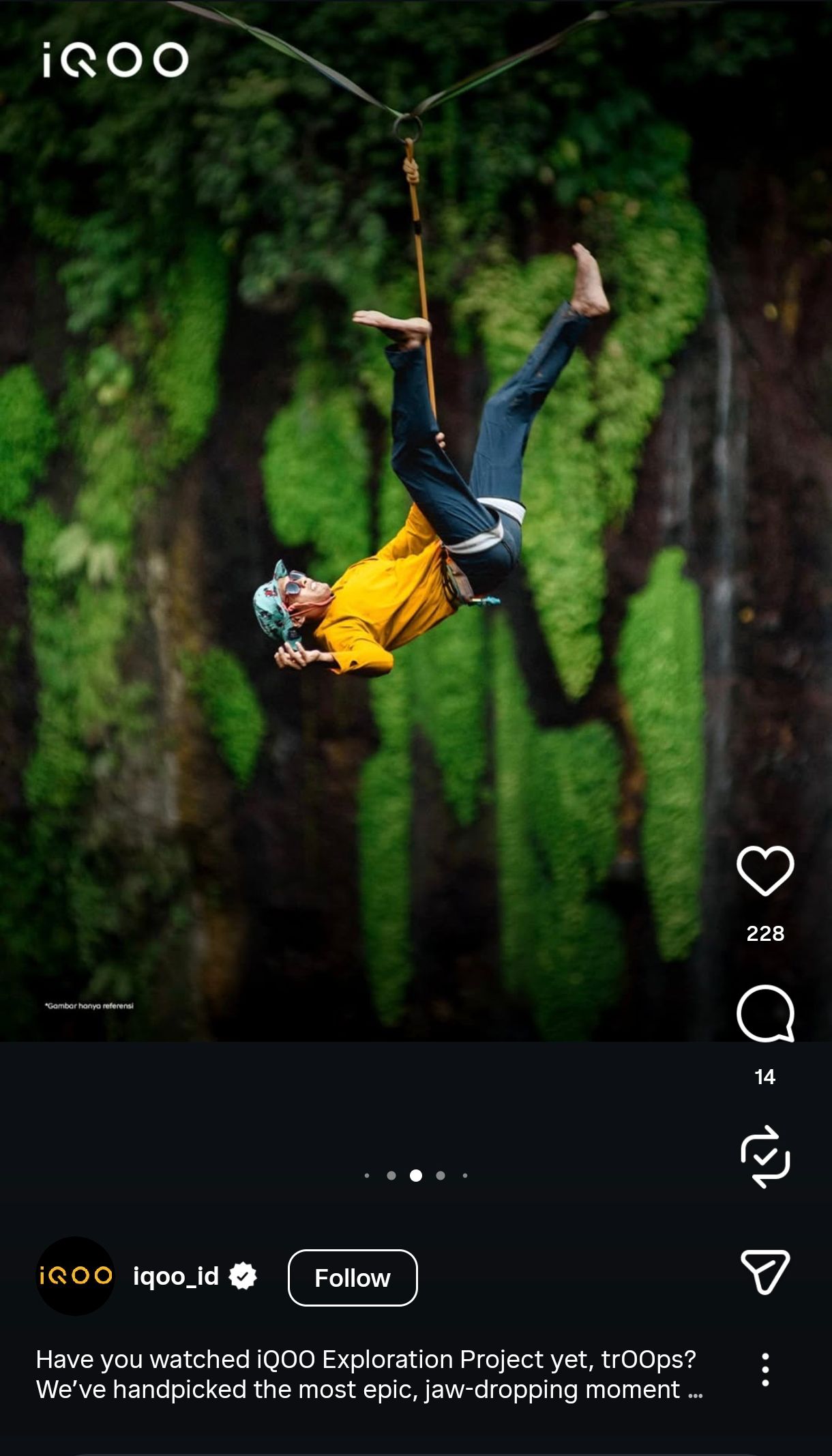 Silhouetted figure in yellow shirt performs dramatic aerial bungee jump against lush green forest backdrop.