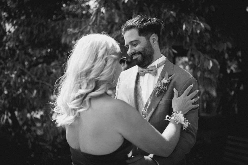 A romantic black and white photo series showing intimate moments between a couple on their wedding day.