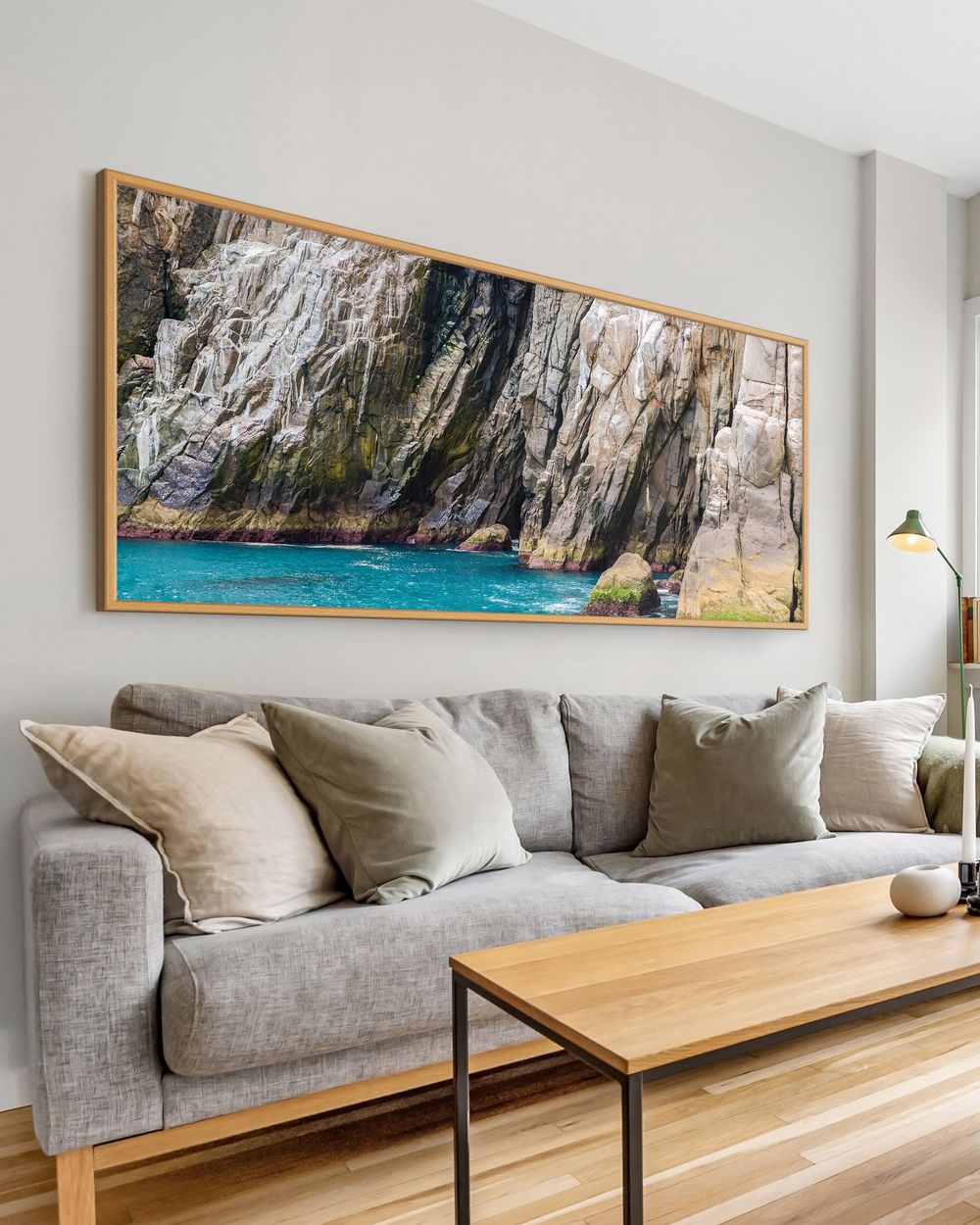 Quadro decorativo de grande formato com fotografia de rochas e água turquesa em ambiente de sala. Orçamento para quadros personalizados.