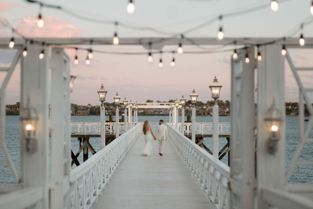 White wooden church pews line both sides of an aisle leading to an altar under hanging string lights.