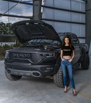 Model posing for a portrait shoot with a Black Dodge Ram TRX in an industrial building in Charleston, SC