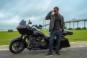 Harley Davidson Road Glide and model posing in  casual attire. Near the Ravenal Bridge in Charleston, SC