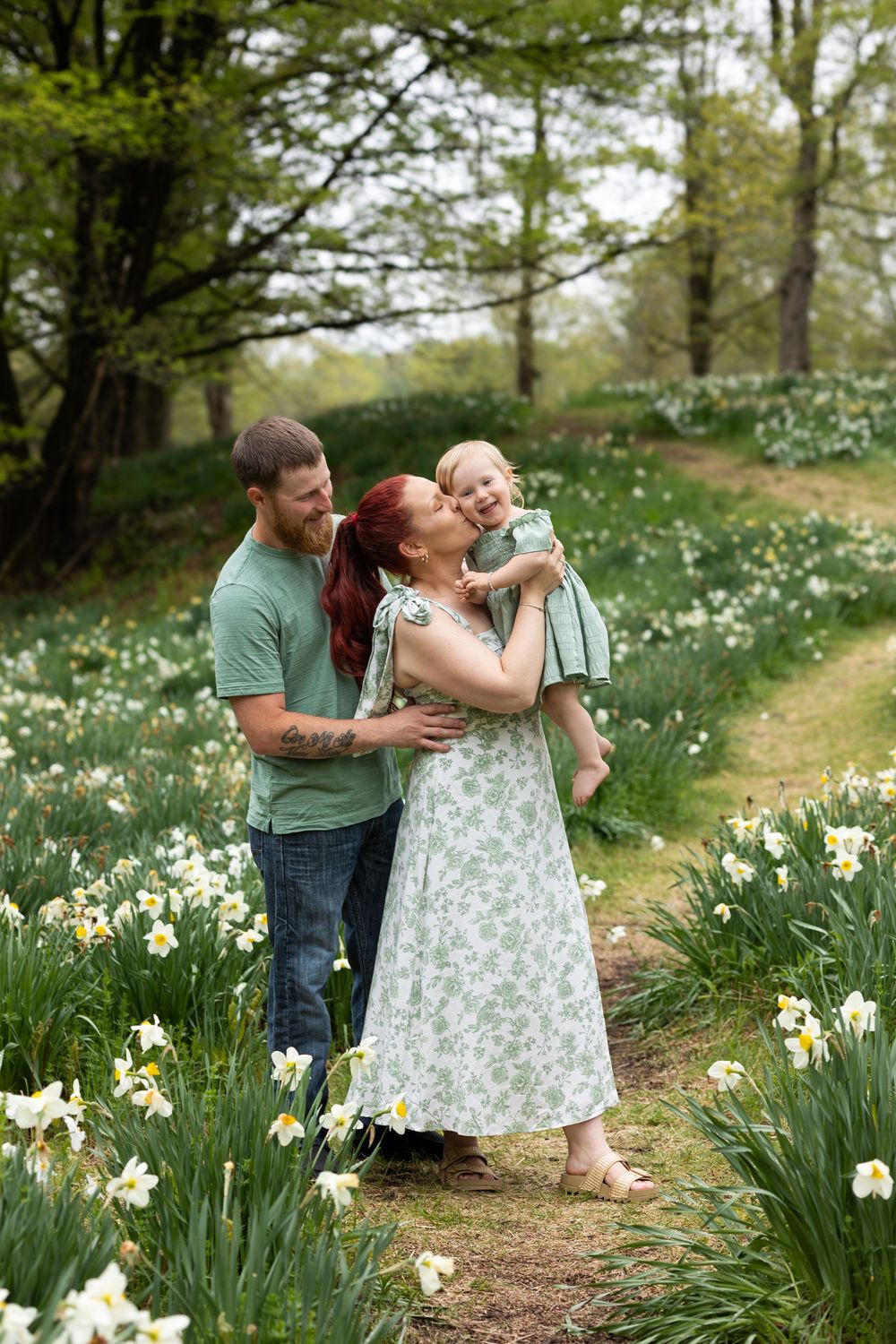 A loving family moment captured in a field of blooming daffodils on a spring day.