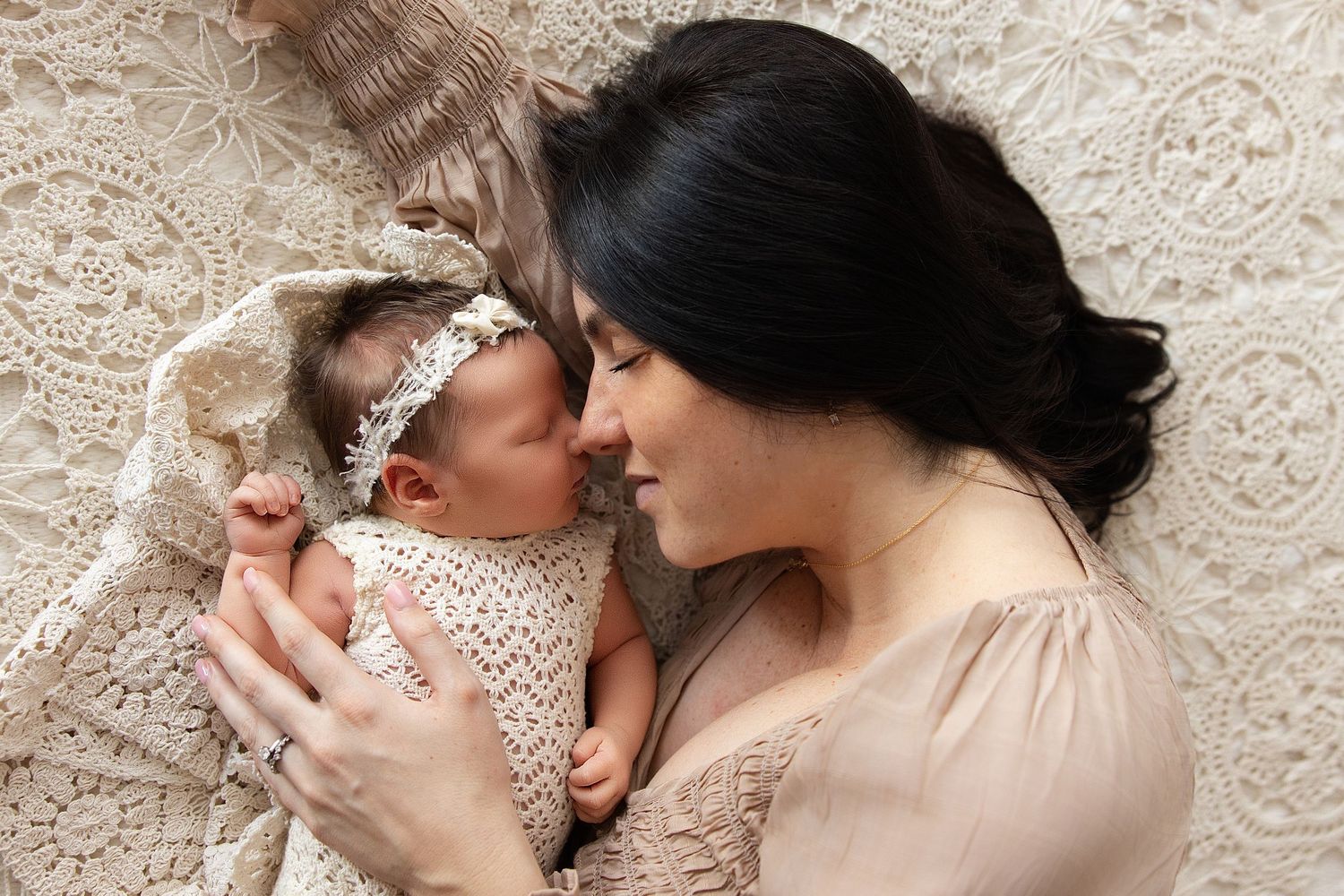 A series of tender black and white photographs showing intimate moments between parent and newborn baby.