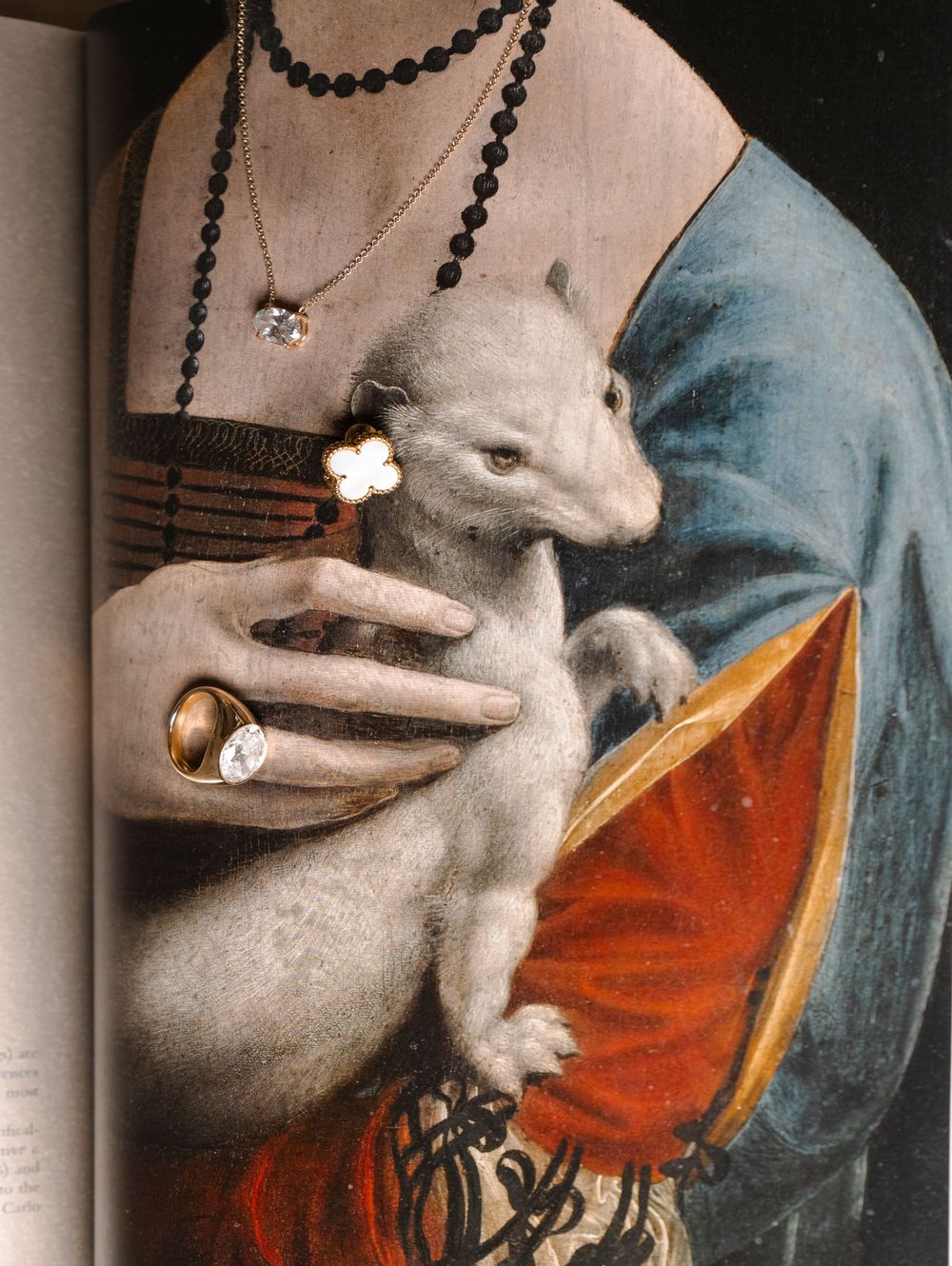 A white ermine is held against a blue and red background while wearing a pearl necklace in this Renaissance-style painting detail.