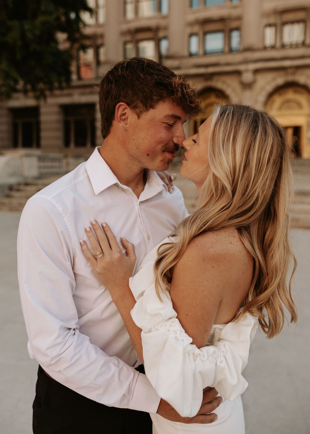 A romantic couple in wedding attire share intimate moments in a series of connected photos against a stone building backdrop.