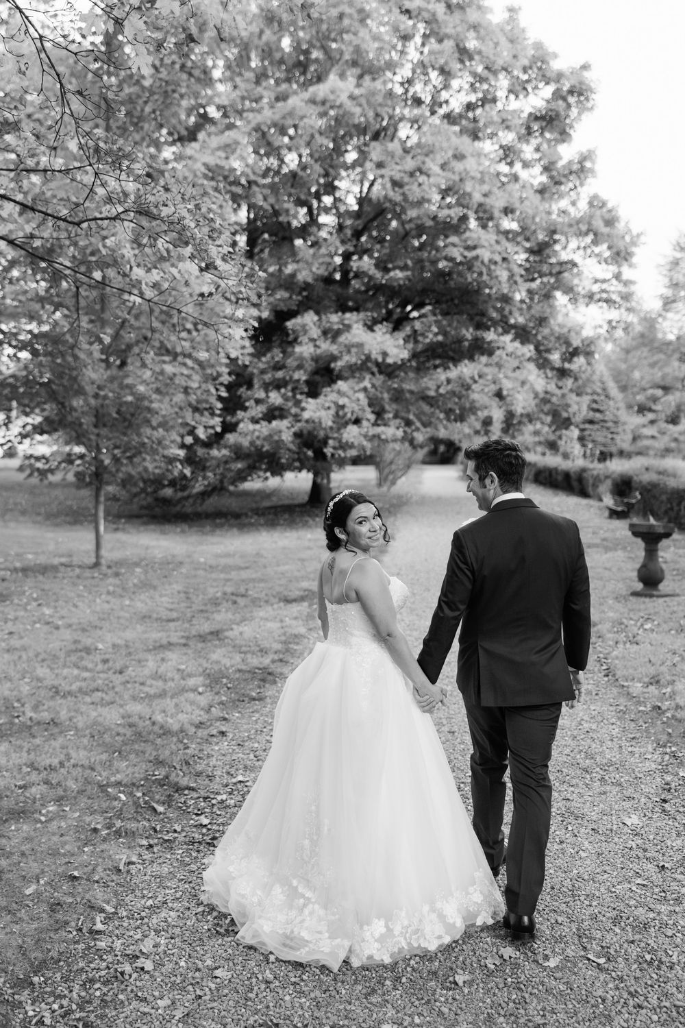 A black and white wedding sequence shows a couple walking away together through a garden setting.