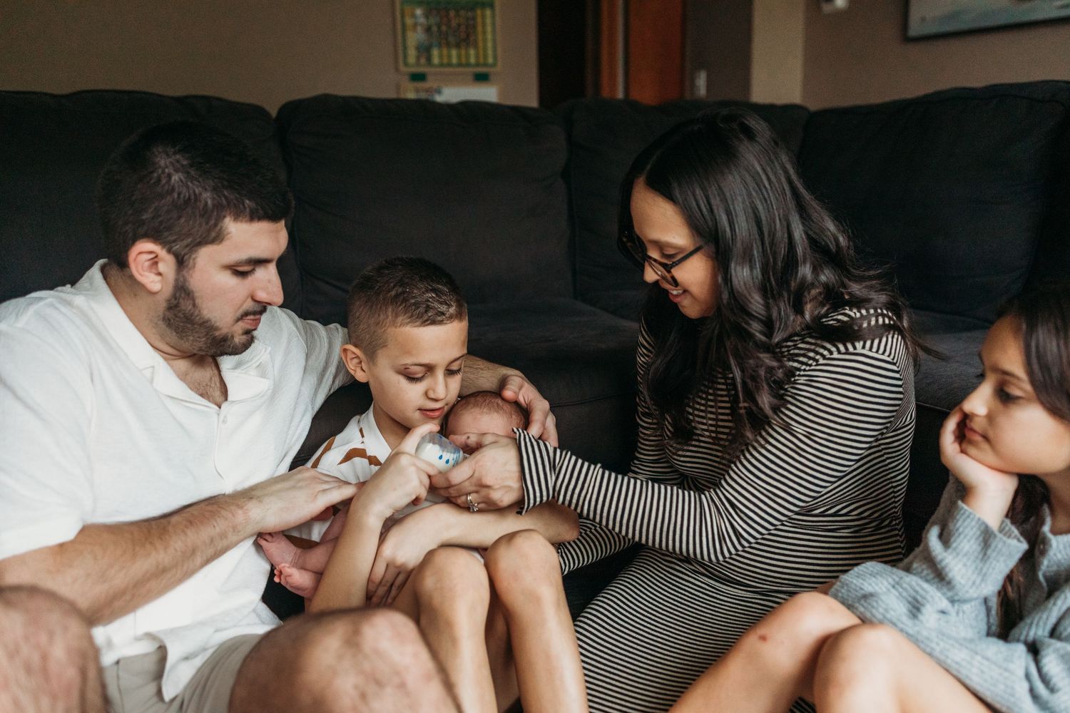 Family members sit together on a couch sharing intimate moments of comfort and connection.