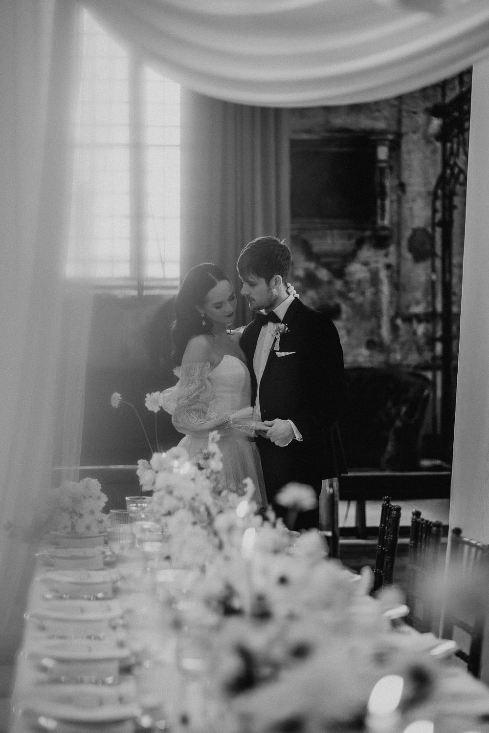 Elegant wedding reception table settings with white decor and floral arrangements.