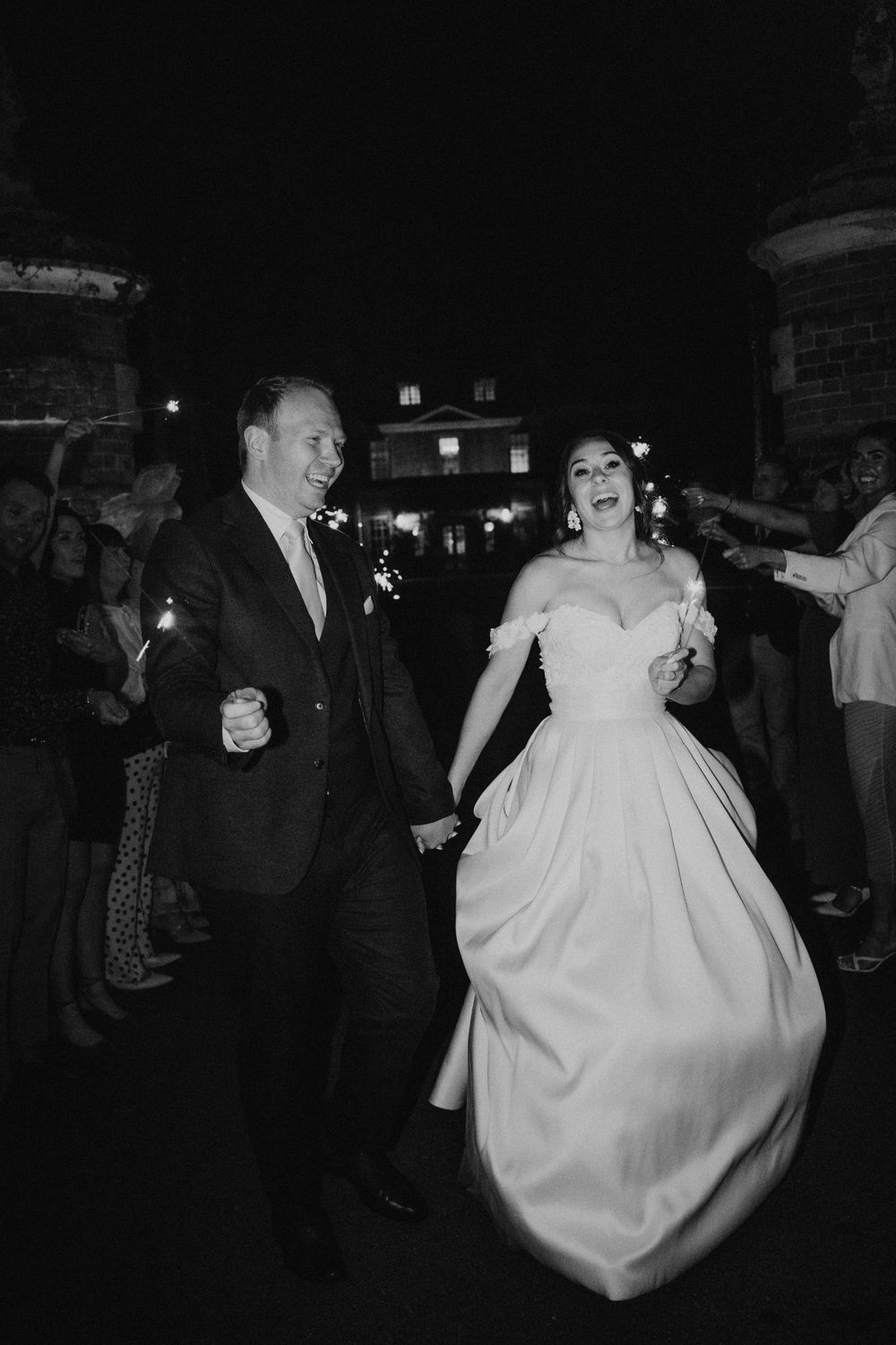 Wedding celebration on a dance floor with guests in formal attire at night.