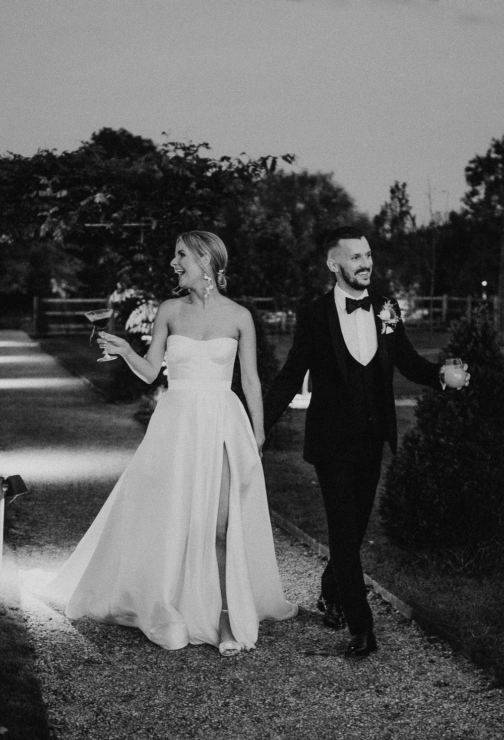 Elegant black and white wedding photos captured outdoors in a garden setting.