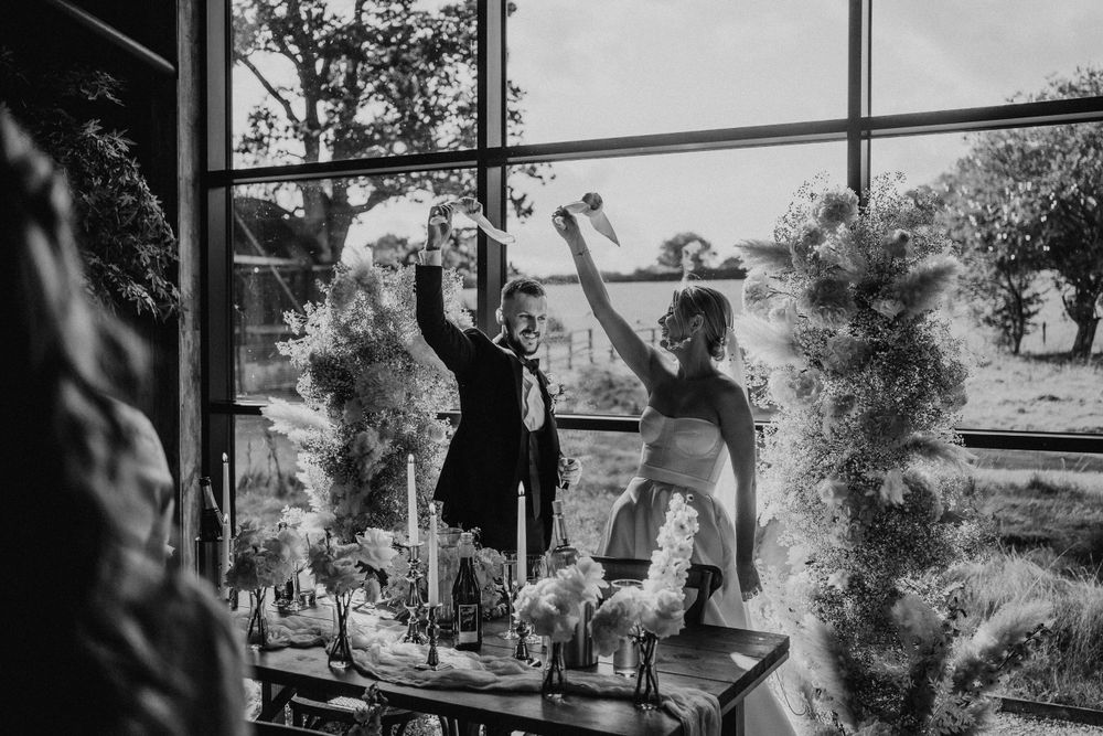 Black and white photos of wedding guests celebrating by a large window.