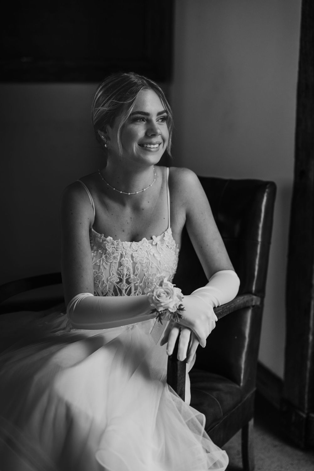 Black and white photos show close-up details of an elegant lace wedding dress in an indoor setting.