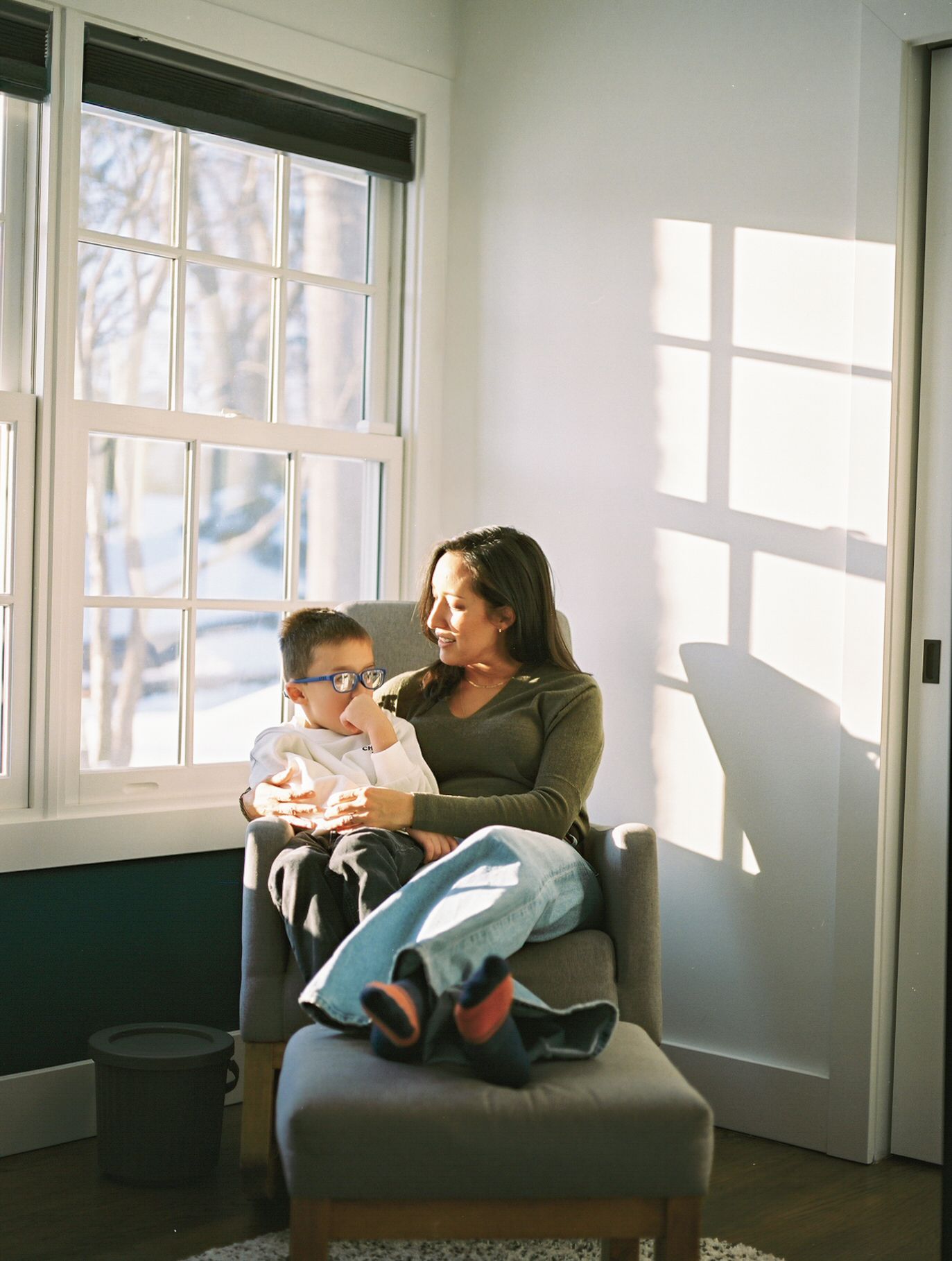 A beautiful film image of a mother and son sitting in front of a window during a lifestyle session in the winter in NJ.