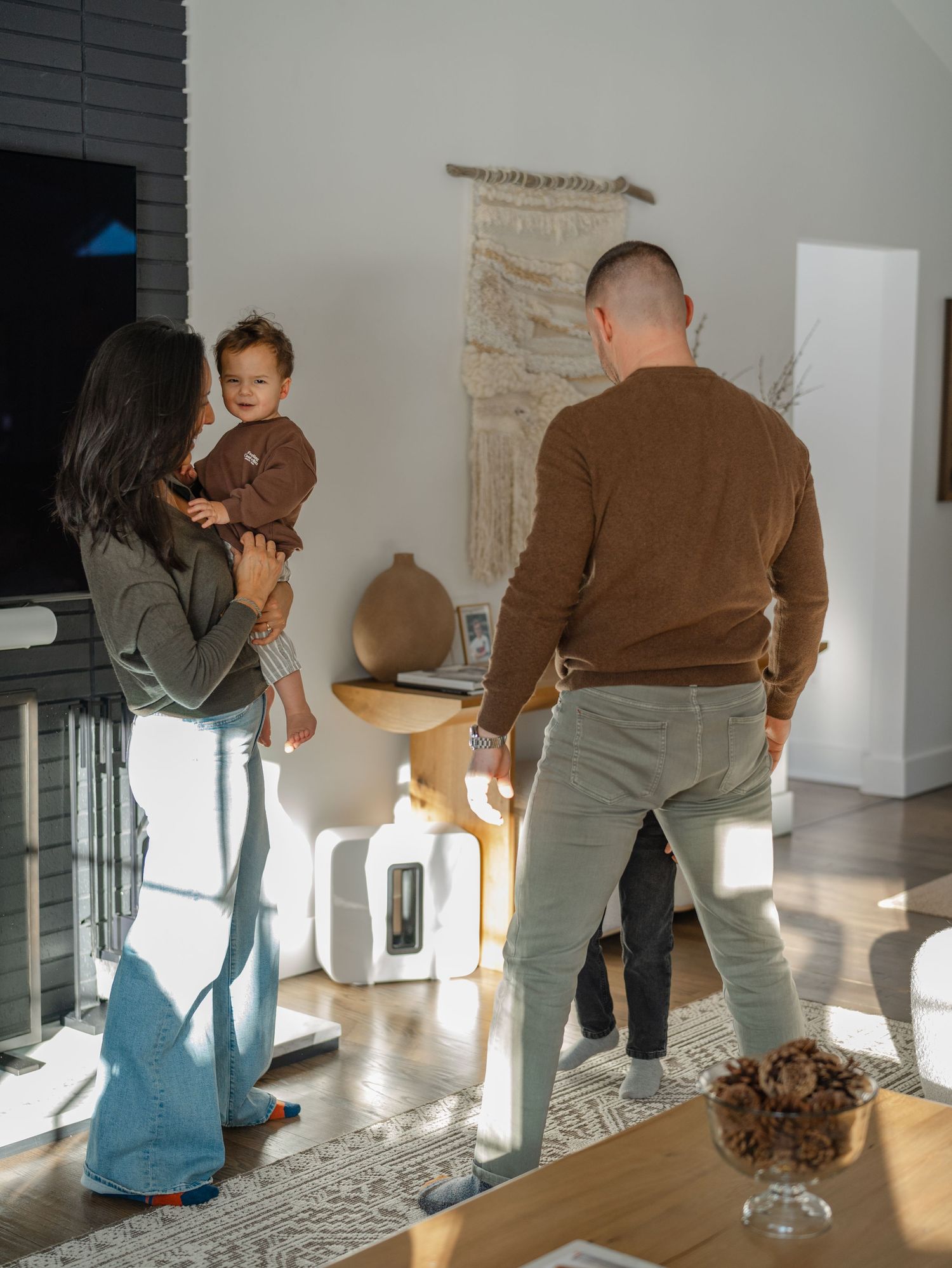 Family laughing together in their living room during a New Jersey in-home family photo session.