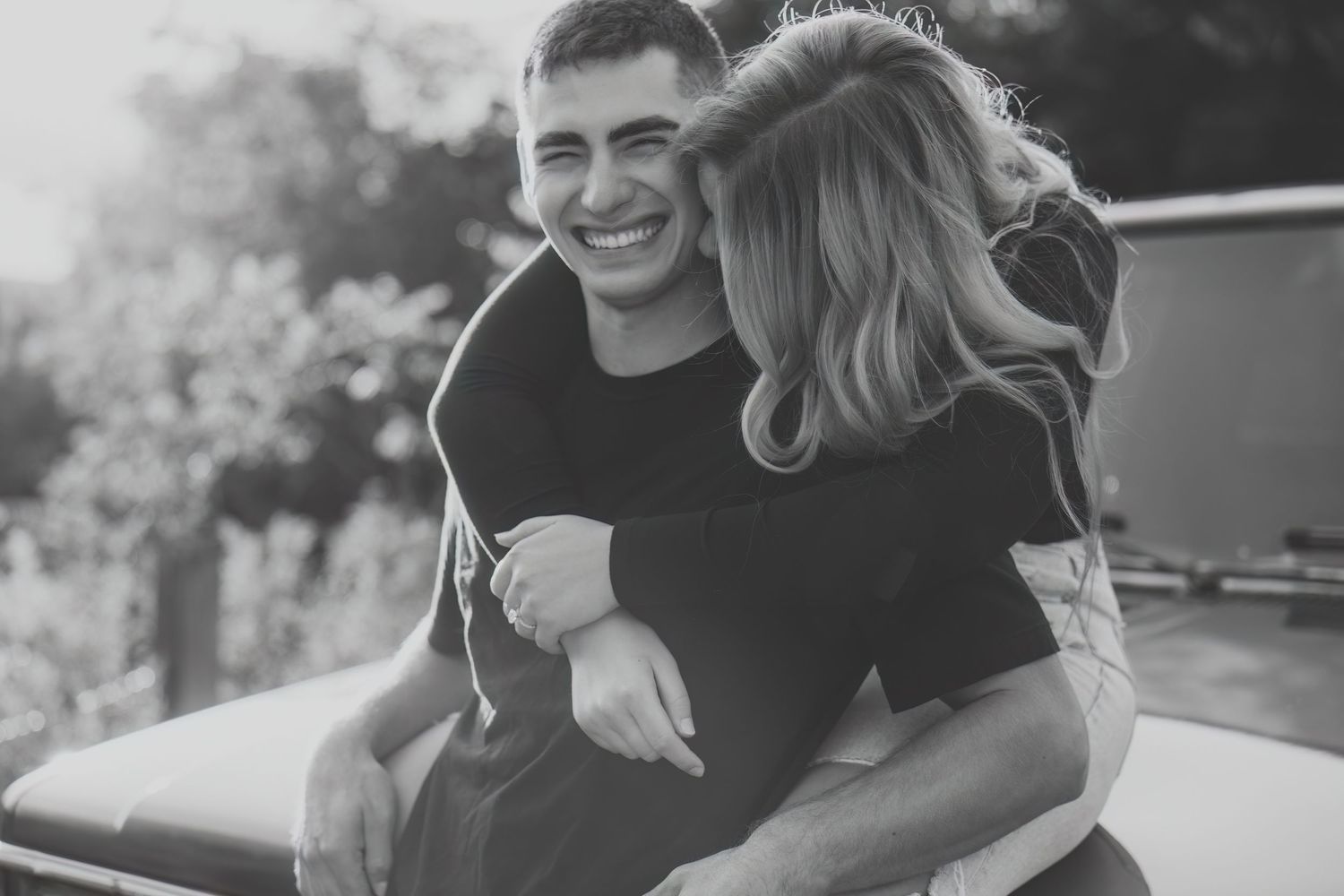 A series of black and white candid photos showing joyful moments between couples outdoors.