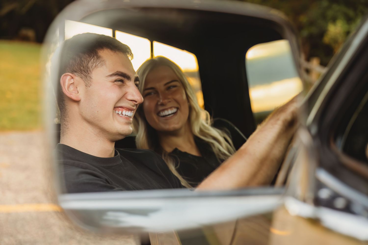 Happy couple sharing joyful moments while driving together in a car.