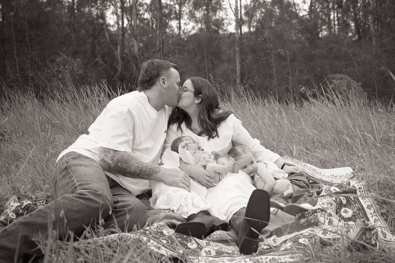 Maitland Newborn baby Photographer captured young family holding newborn surrounded by bushland