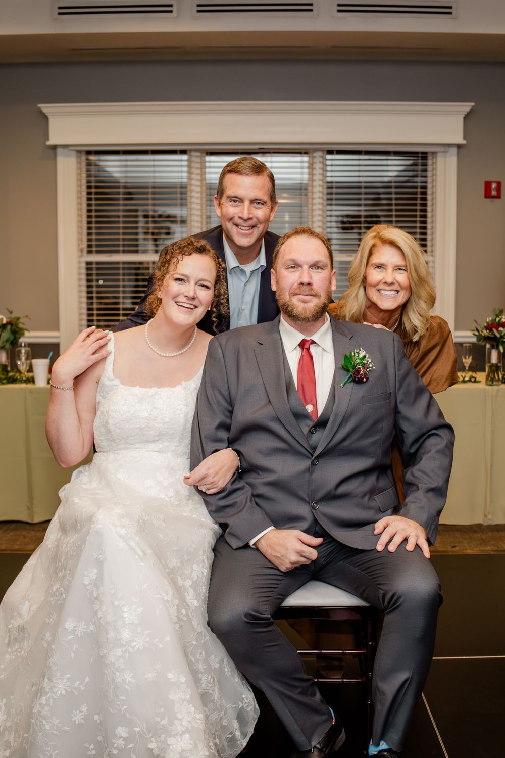 A wedding couple and their guests pose playfully for a series of candid reception photos in an indoor venue.