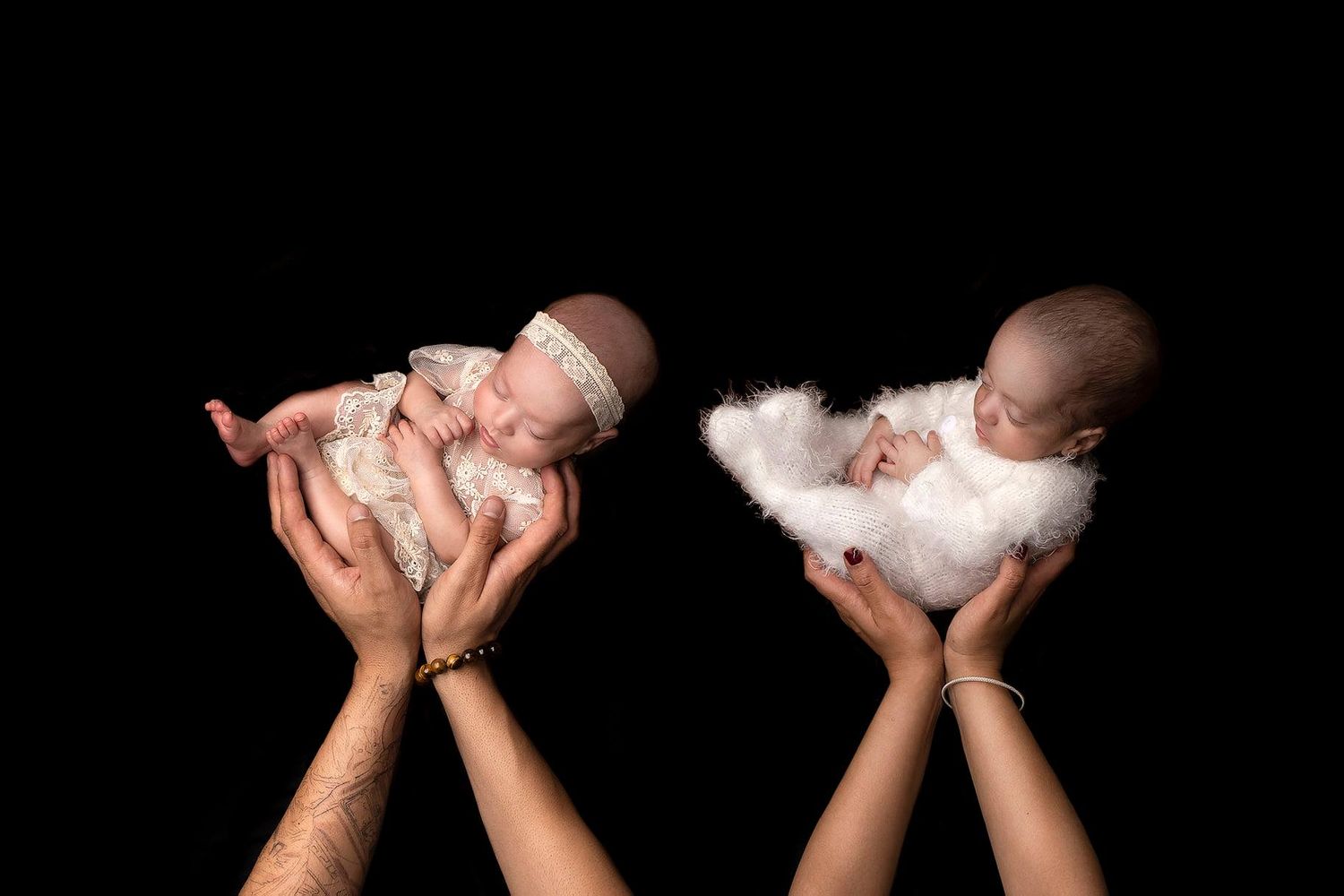 Hands hold a small white puppy in different gentle poses against a black background. Elizabeth Lang Photography Surrey