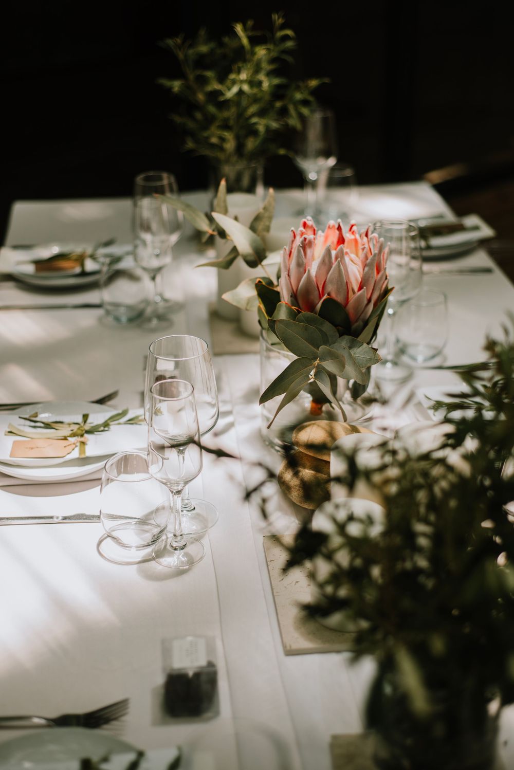 Elegant minimalist wedding decor at Die Woud Wedding Venue featuring king proteas and olive leaves in a refined, natural styling