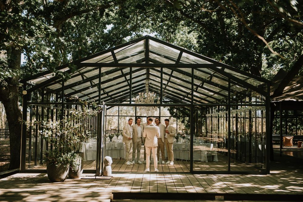 Groomsmen and Groom having a quiet moment inside the venue at Die woud.