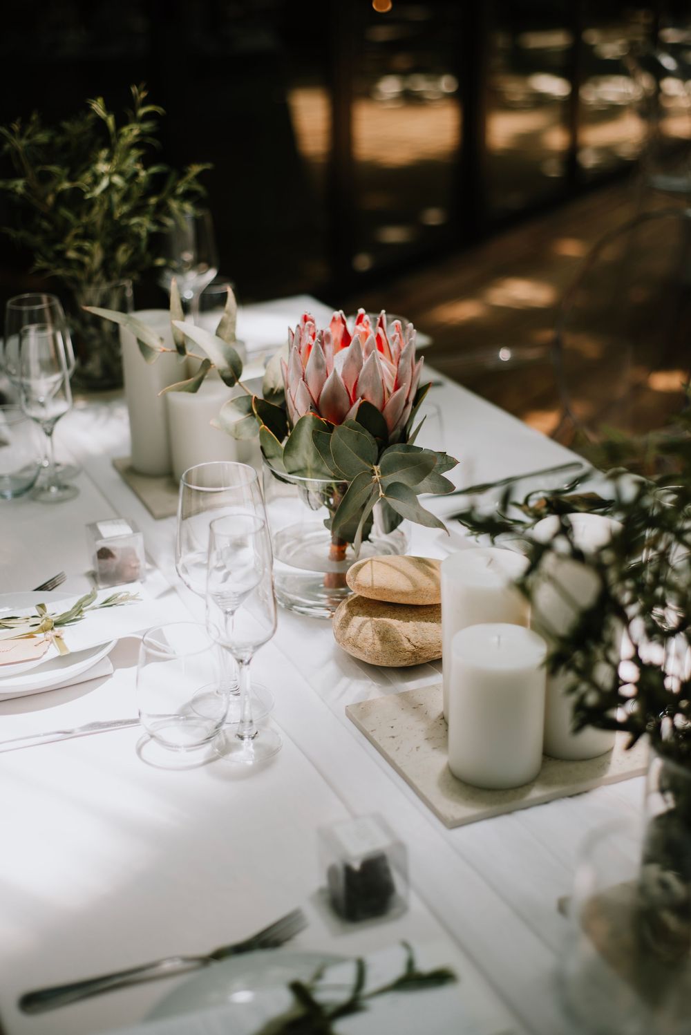 Elegant minimalist wedding decor at Die Woud Wedding Venue featuring king proteas and olive leaves in a refined, natural styling