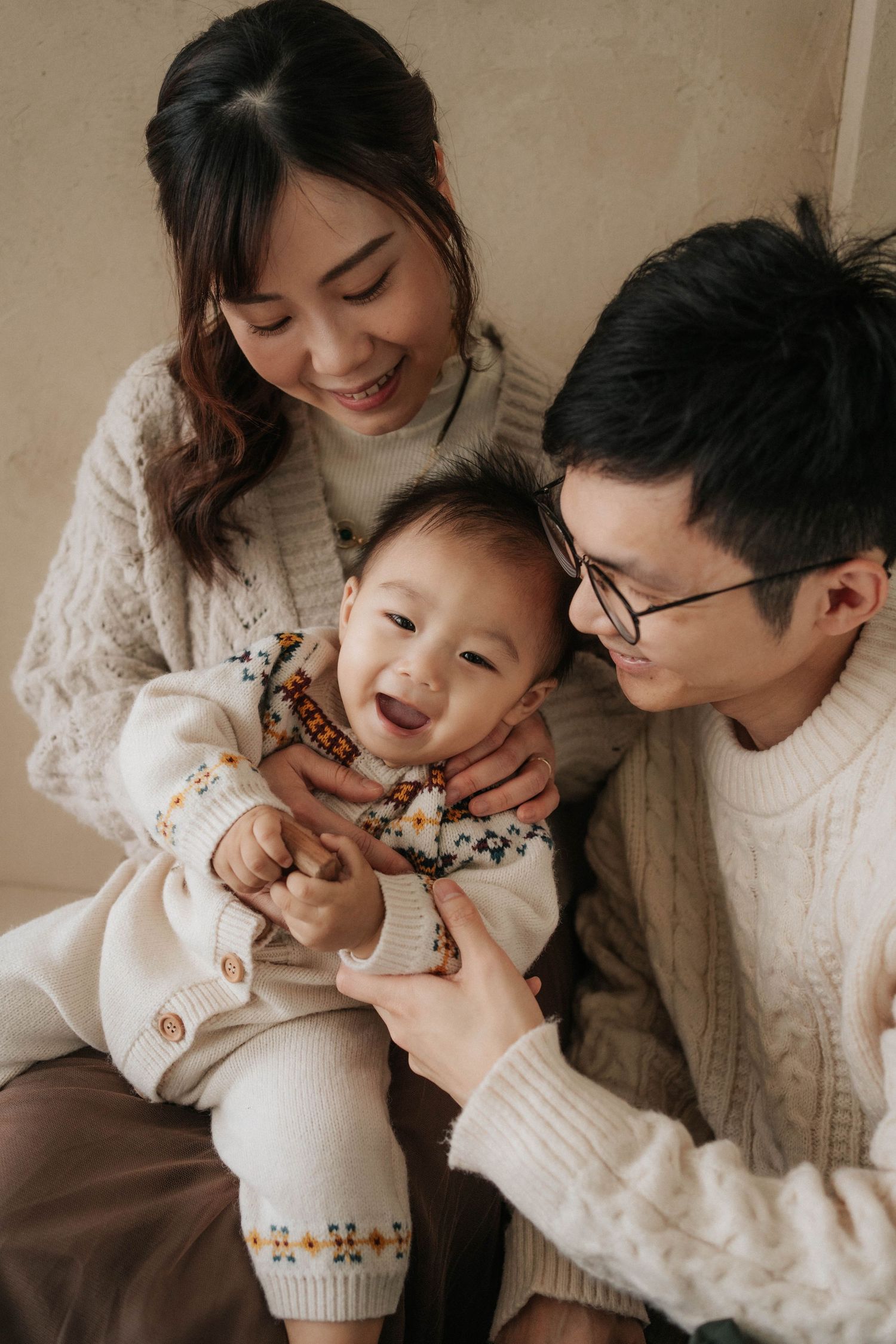 A family in cream and white sweaters shares tender moments and laughter together in a series of candid photos.一組抓拍的照片顯示，一家人身穿米白色毛衣，分享溫馨的時刻