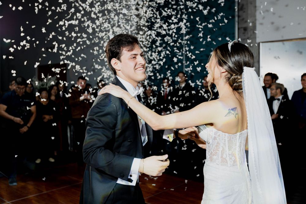Romantic first dance moment with confetti falling during wedding reception.