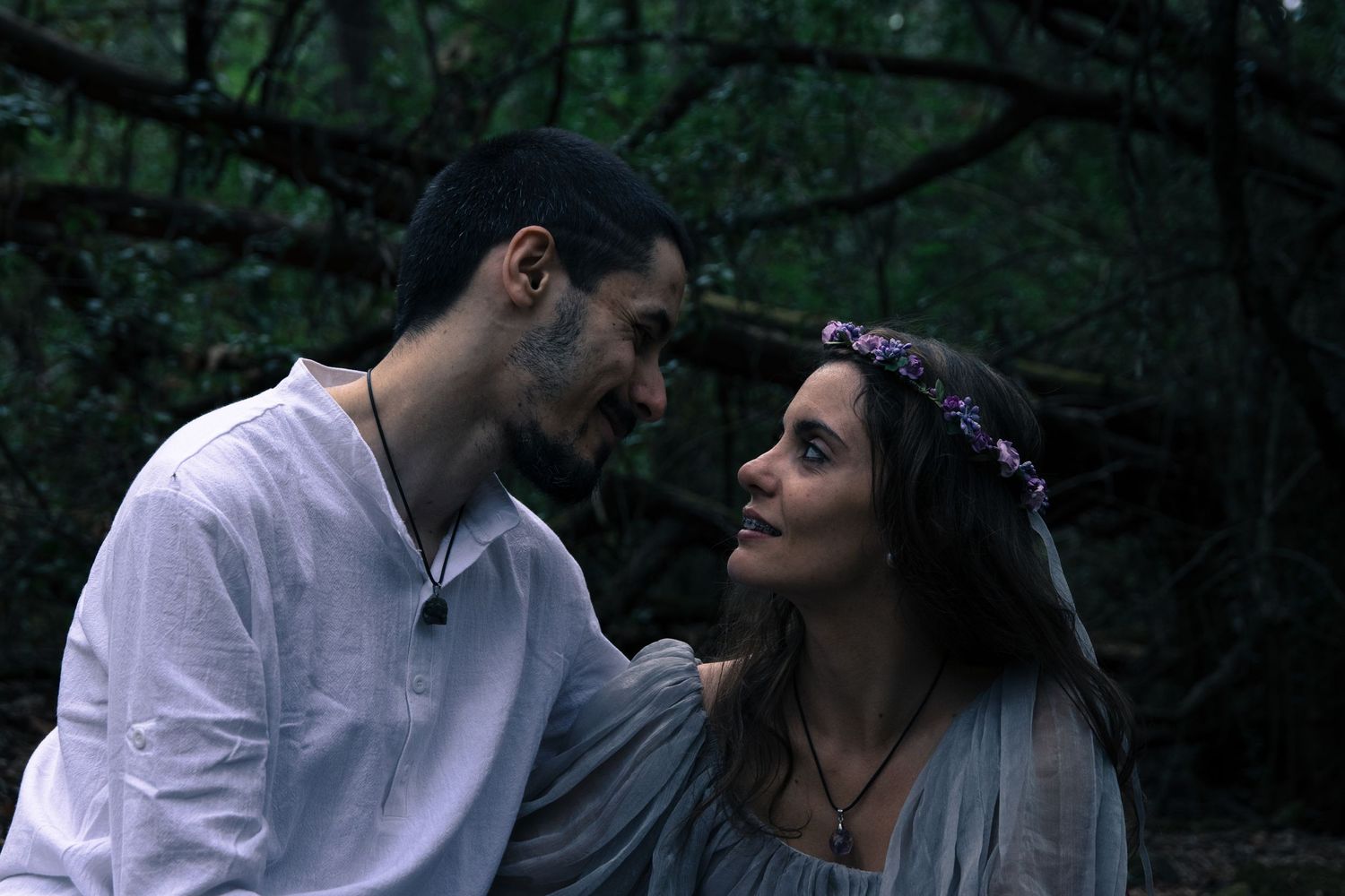 Romantic woodland couple photoshoot with natural lighting and forest backdrop.
