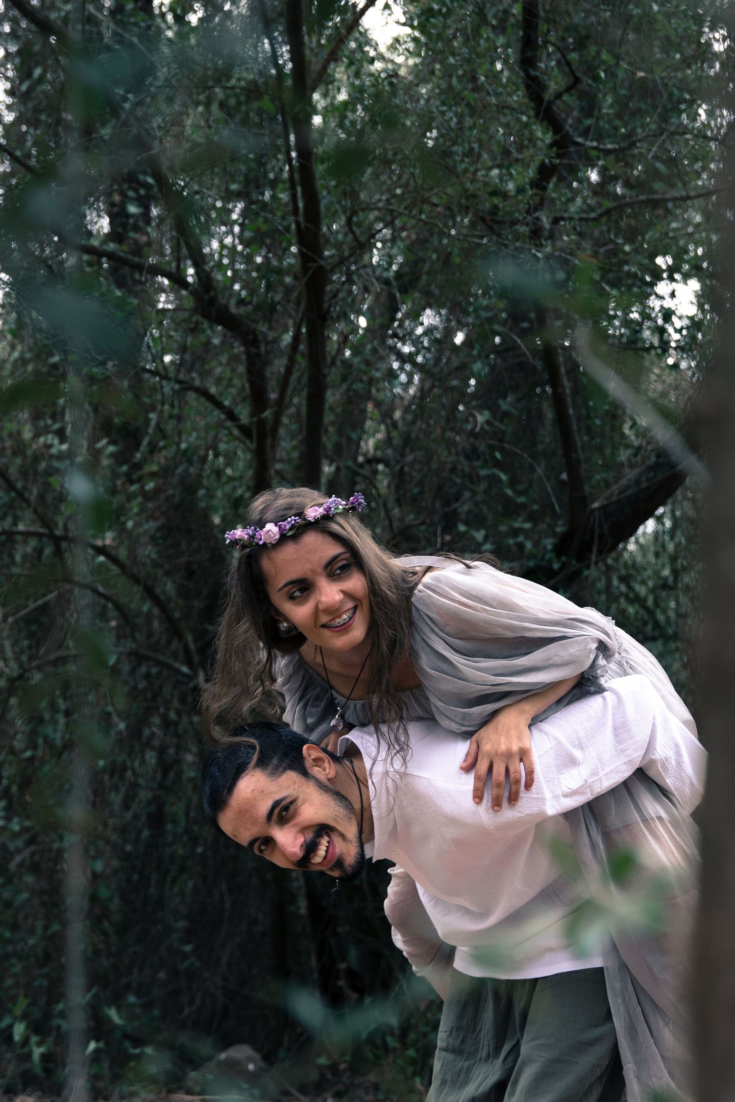 Playful sequence in a forest setting with someone wearing a white top and flower crown.