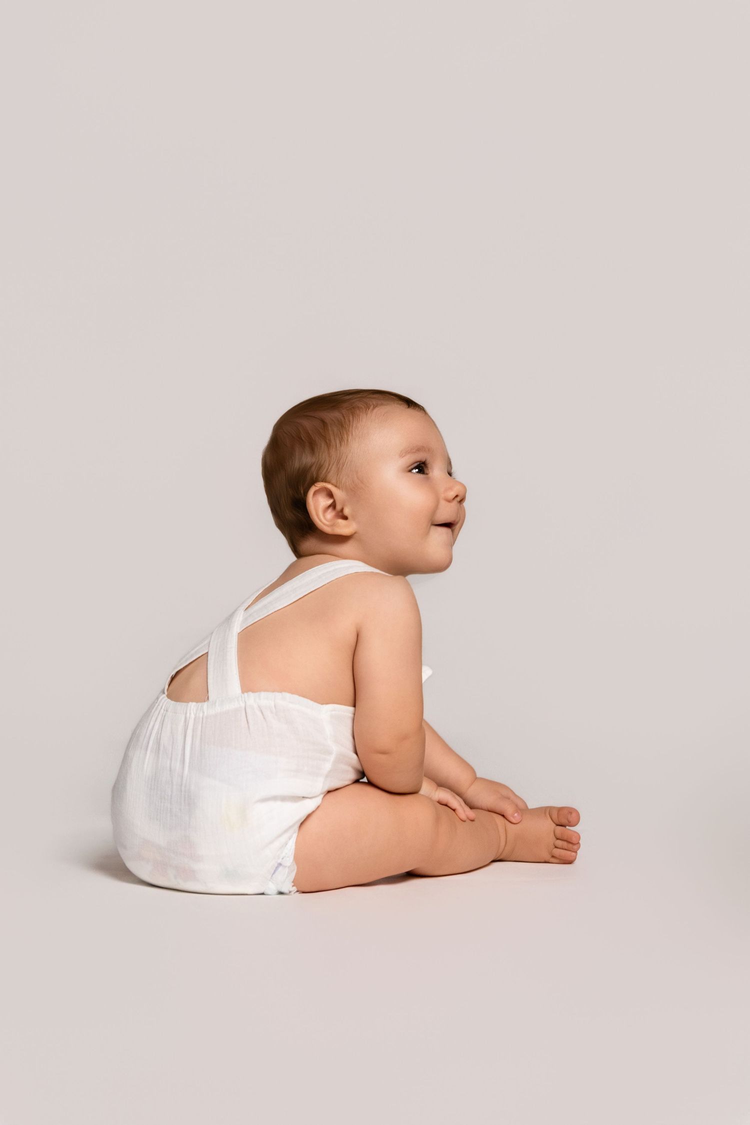 A simple studio portrait showing movement and expression against grey background.