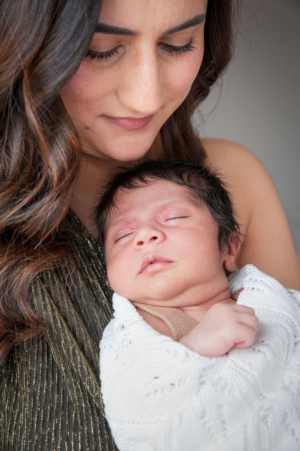Close-up portrait showing a gentle embrace between parent and sleeping newborn swaddled in white.
Altona Family Photographer Melbourne