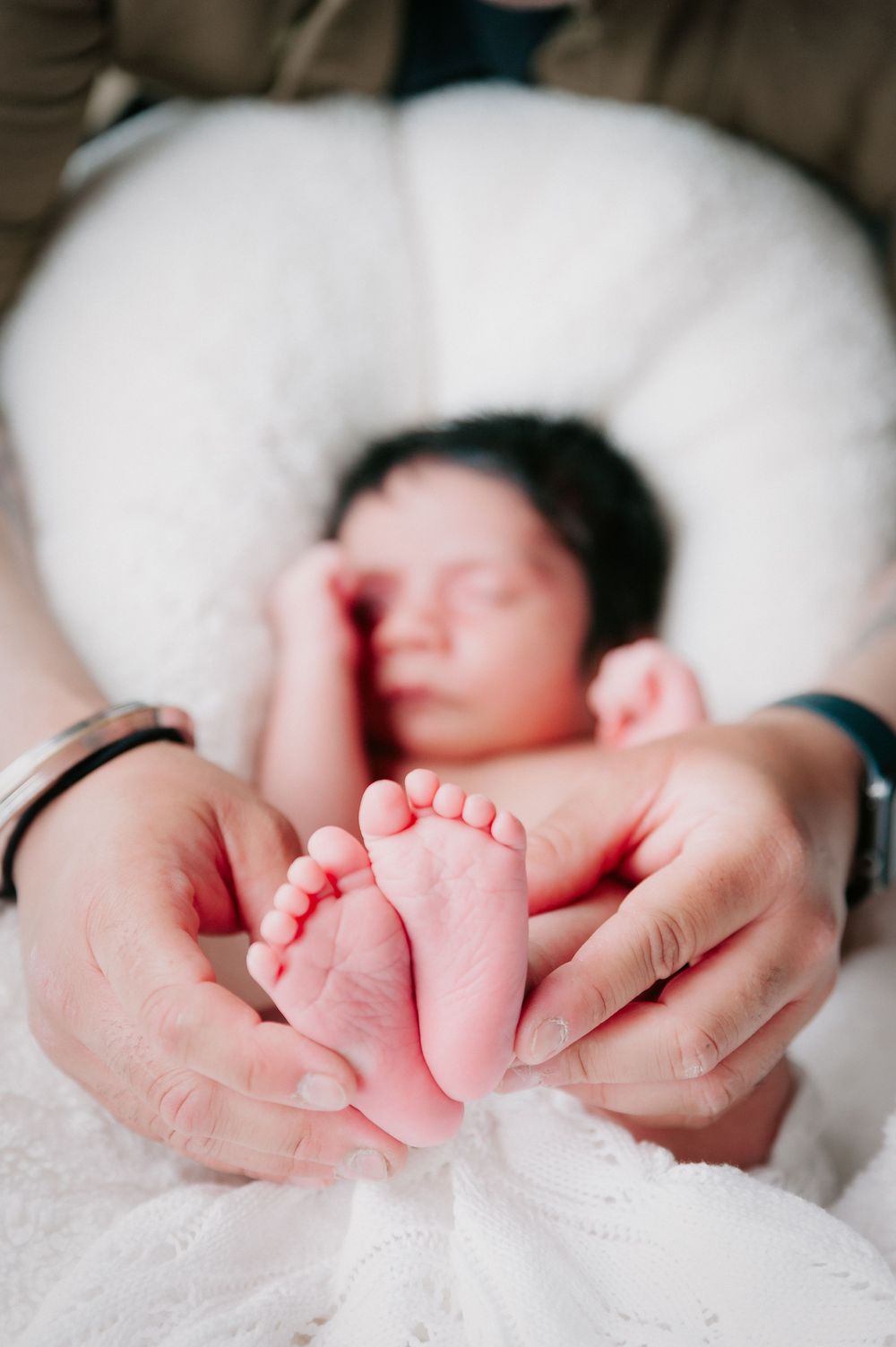 Tiny baby feet resting on white blanket with adult hands gently cradling them.
Altona Family Photographer Melbourne