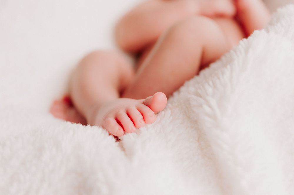 Close-up of tiny baby feet resting on soft white blanket showing delicate toes in gentle light.
Altona Family Photographer Melbourne