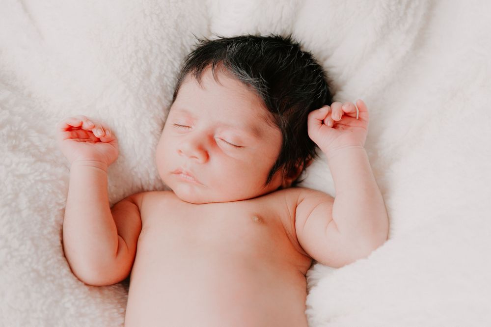 Peaceful newborn baby sleeping with arms raised on soft white blanket.
Altona Family Photographer Melbourne