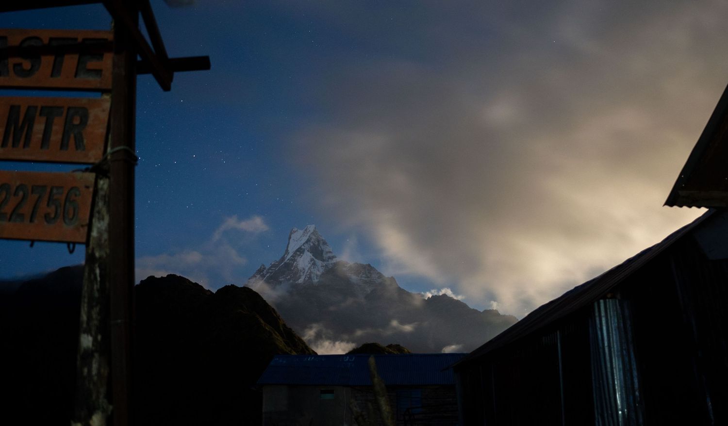 Silhouetted mountain peaks at sunset with dramatic cloud formations.