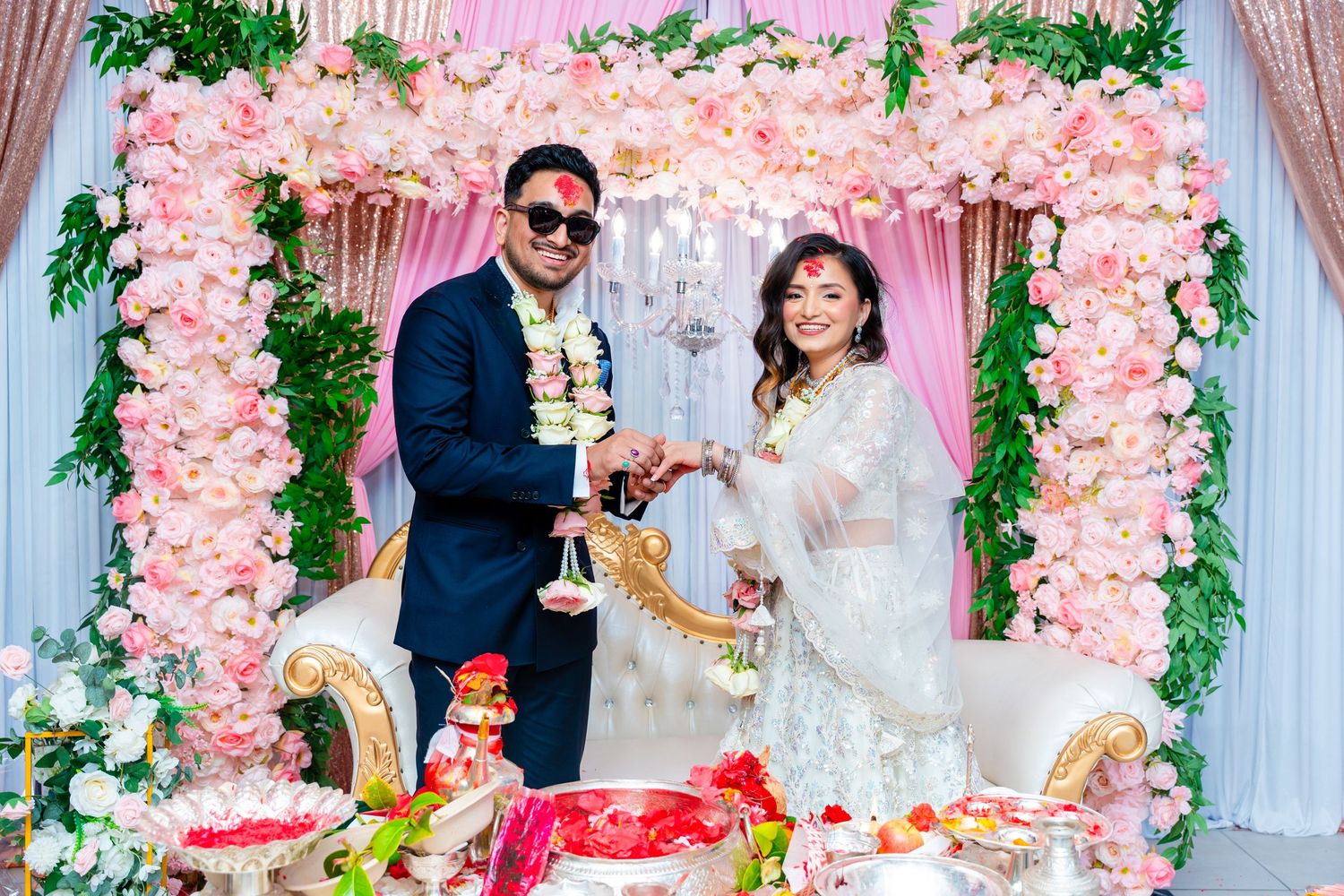Joyful celebration moment under elegant pink floral wedding arch display.