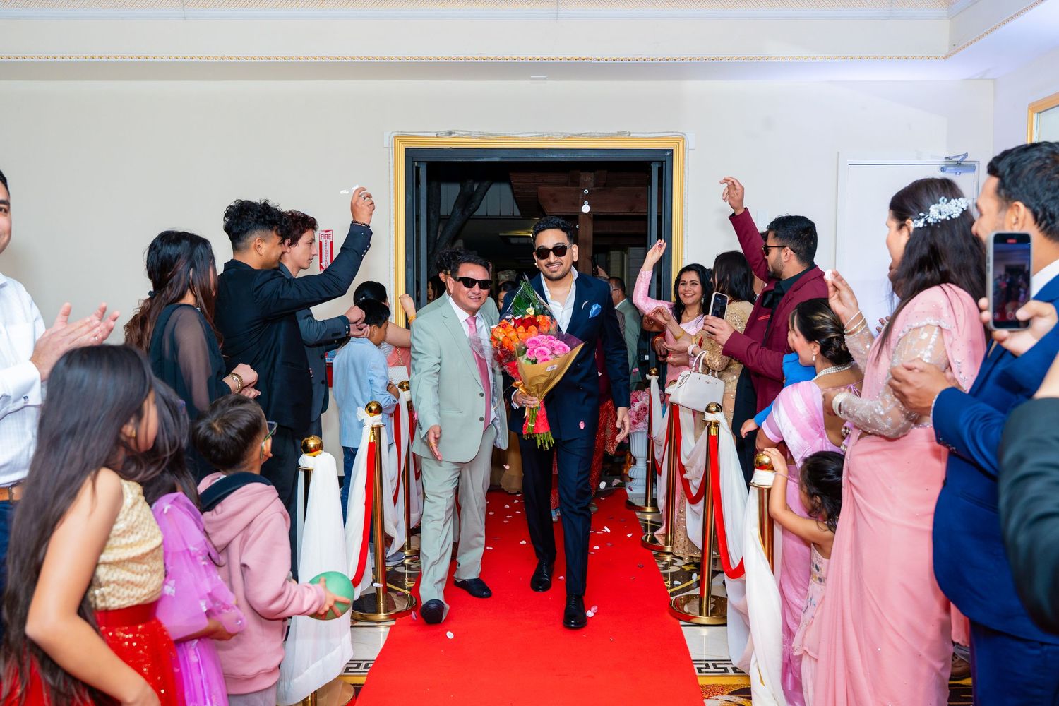 Festive entrance walkthrough on red carpet with guests in formal attire.