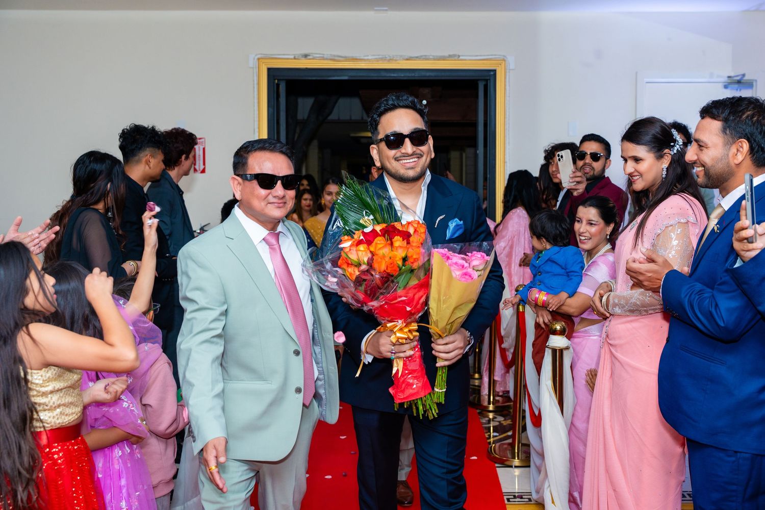 Celebration gathering with guests in formal wear holding bouquets of flowers.