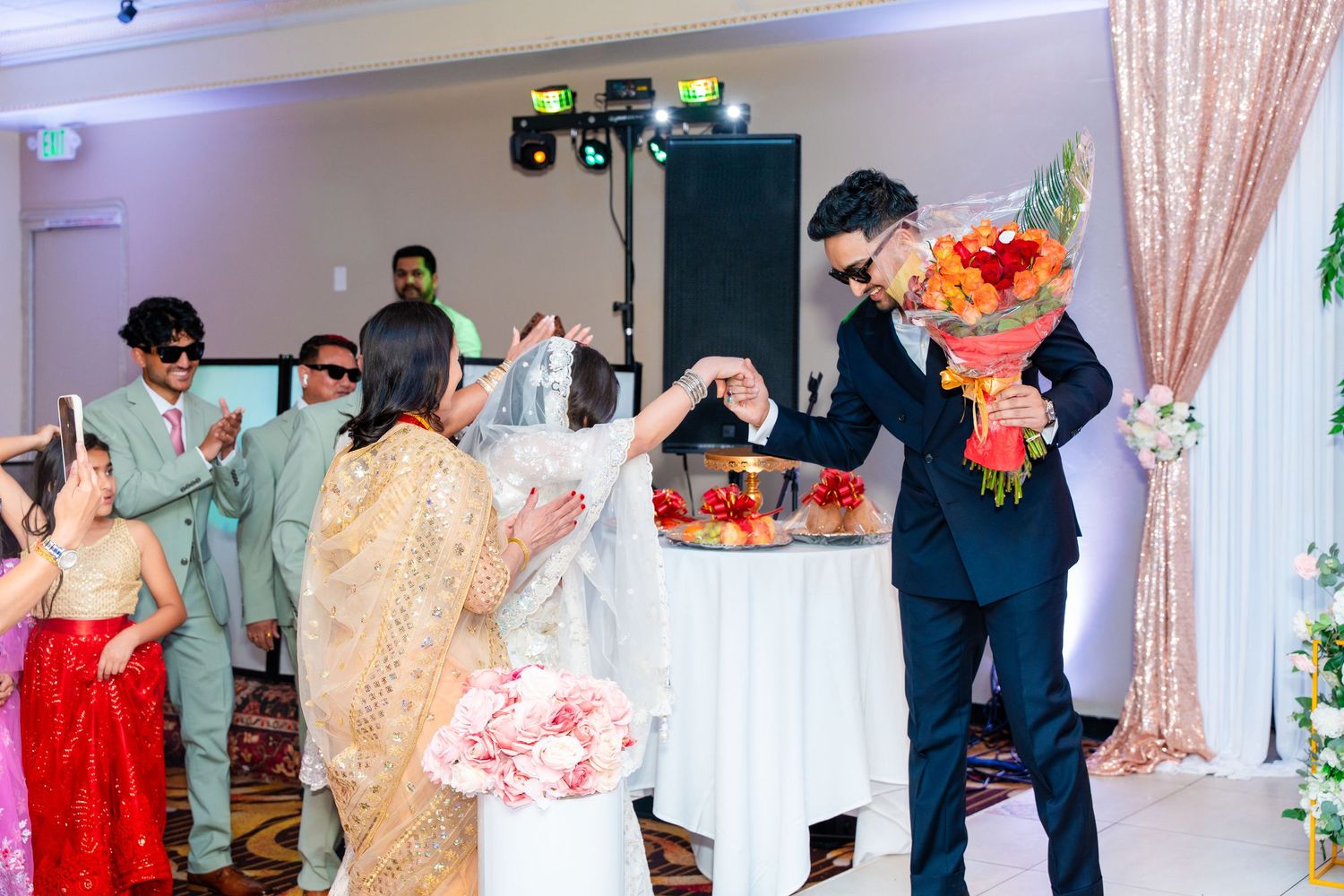 Wedding celebration with guests dancing and celebrating around a decorated table.