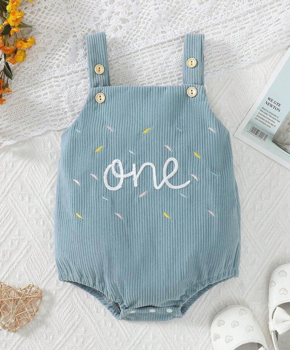 Blue ribbed baby romper with 'one' text and decorative sprinkle pattern.
