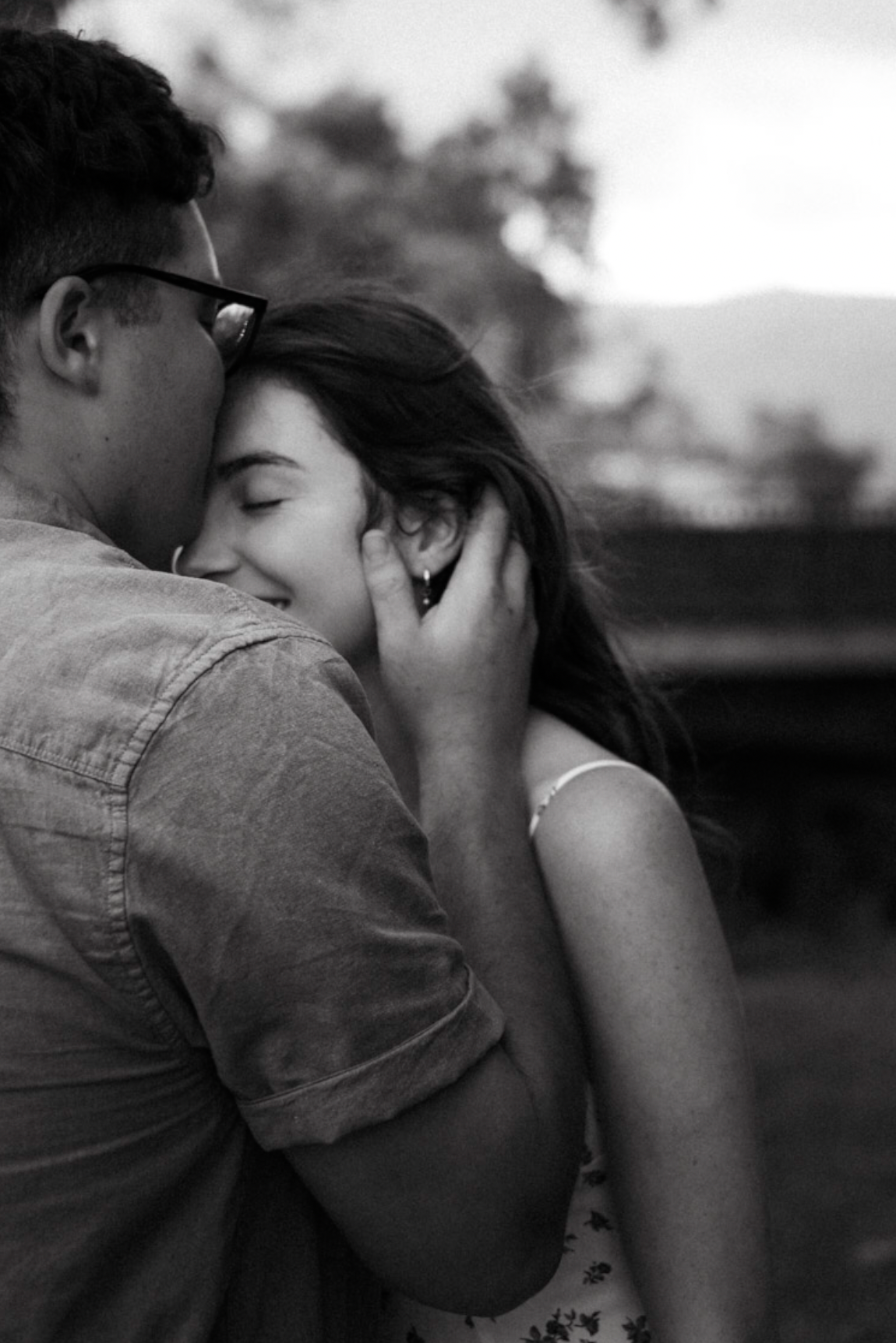 Black and white candid moment captured between two people outdoors.