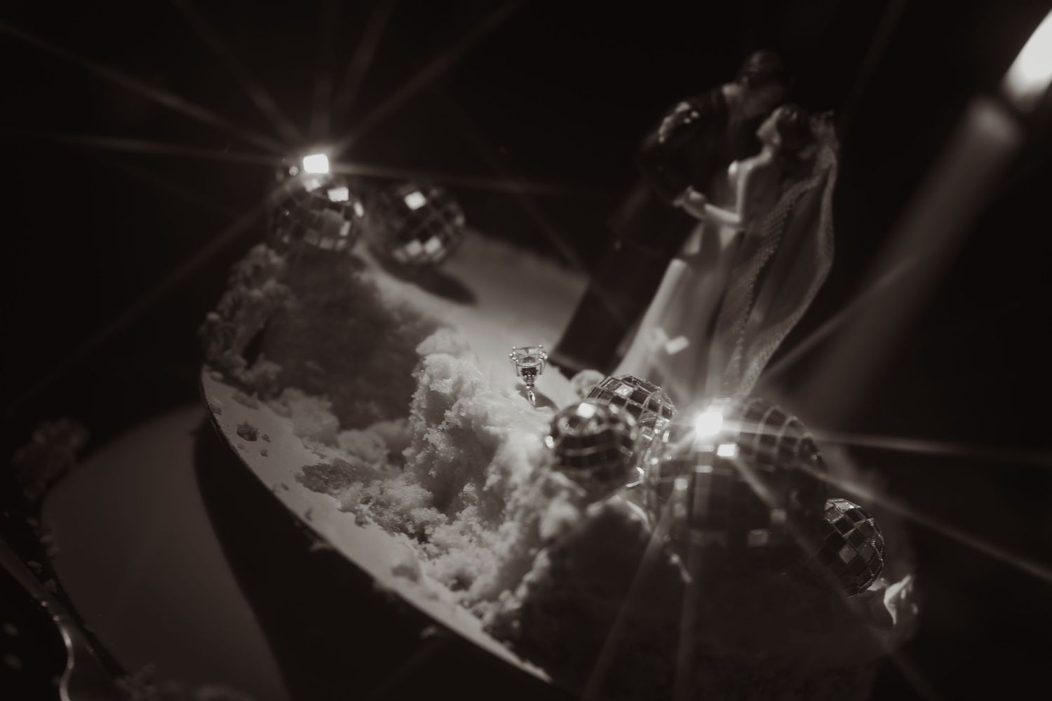Dark reception setting illuminated by soft glow of scattered lights and candles.