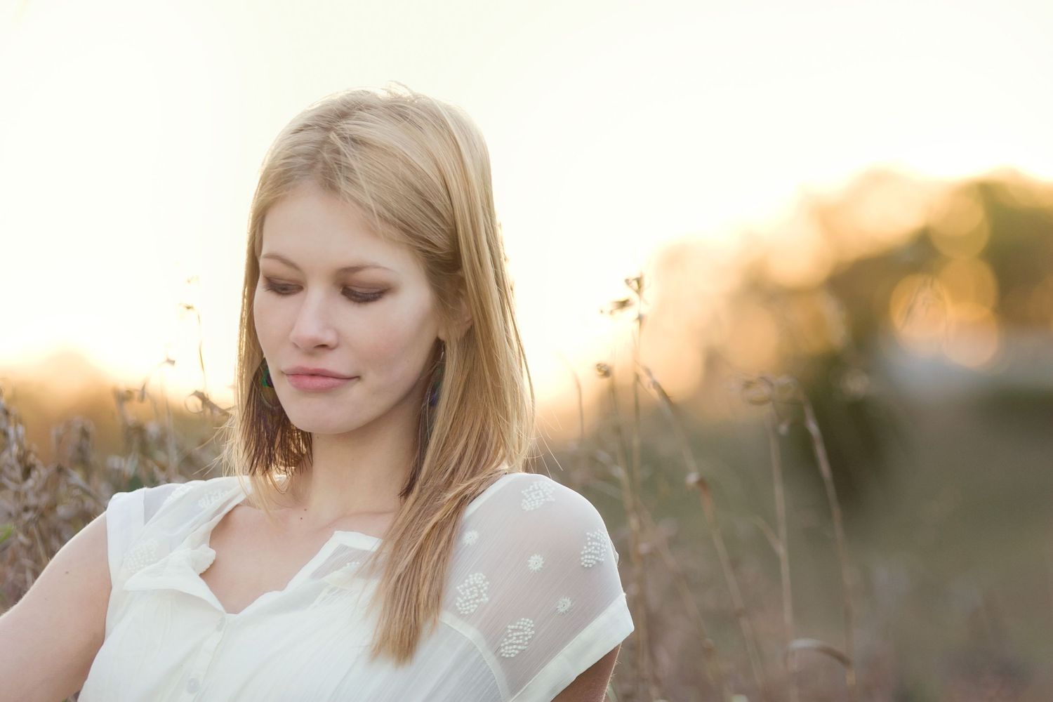 High school senior portrait with film aesthetic in Brighton, Michigan; girl in glowing golden field at sunset by South Lyon, MI photographer