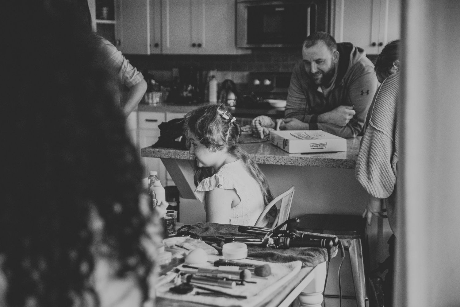 Black and white family photo of a man and two children working together at a kitchen counter.