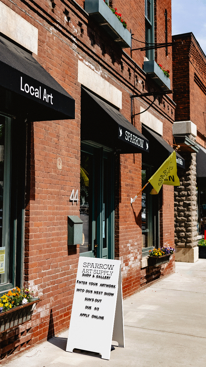 A gif of the green open flag waving outside Sparrow Art Supply in Middlebury, Vermont.
